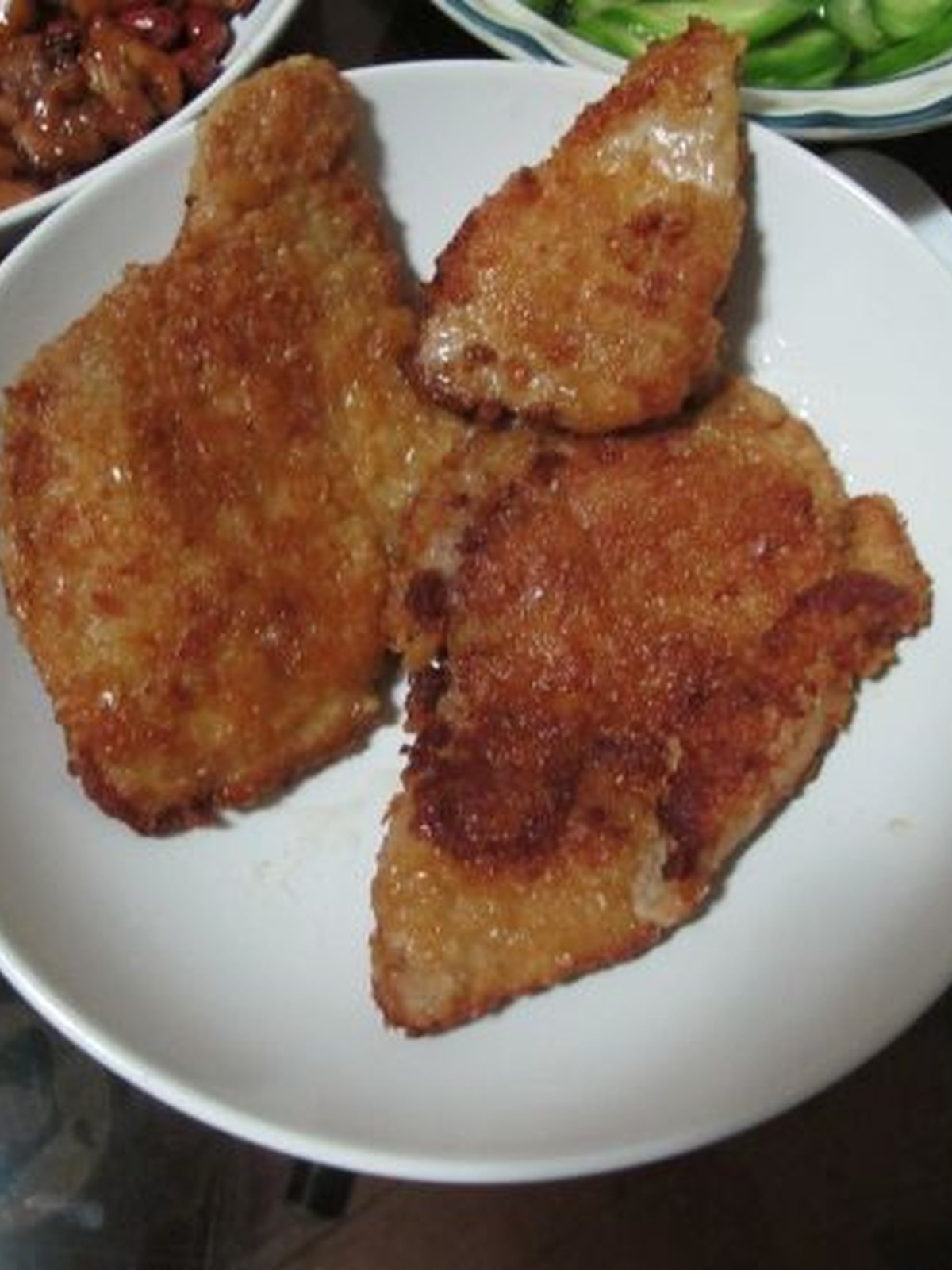 Crisp breaded pork cutlets with lemon wedges and parsley