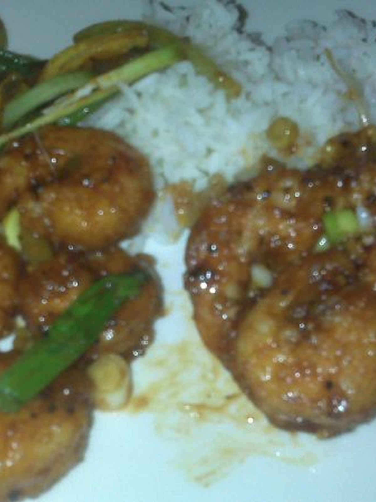 Air-fried lemon pepper shrimp piled on a plate with lemon wedges