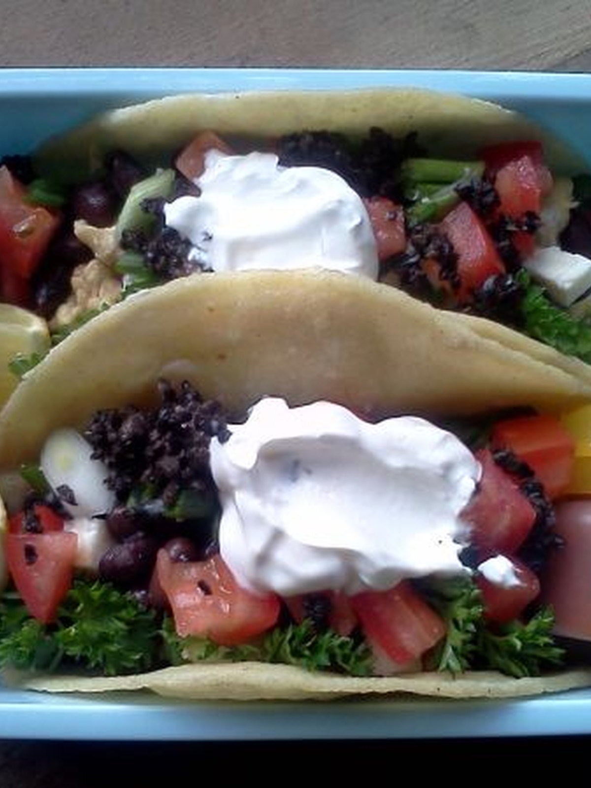 Open breakfast tacos filled with scrambled eggs, black beans, and fresh salsa