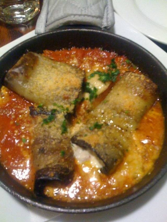Stacked roasted eggplant with ricotta and tomato sauce on a plate
