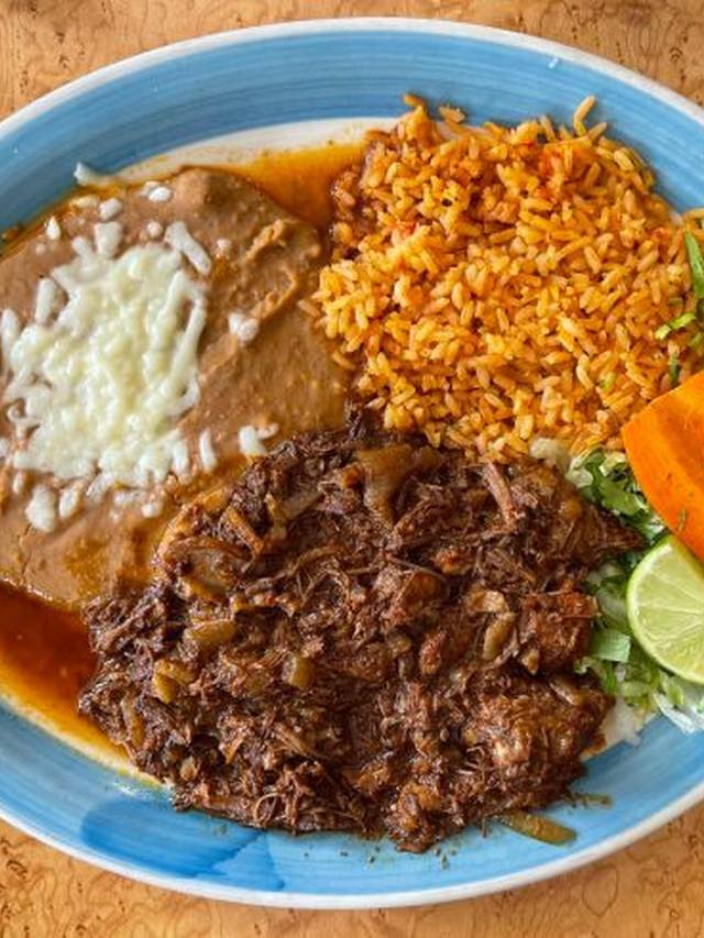 Crisped birria tacos with a cup of consommé