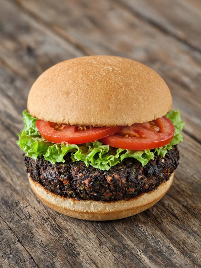 A black bean burger on a bun with lettuce and salsa