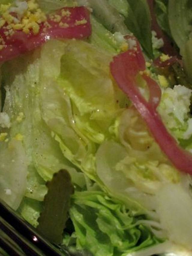 Iceberg wedge salad topped with bacon, tomato, and creamy dressing