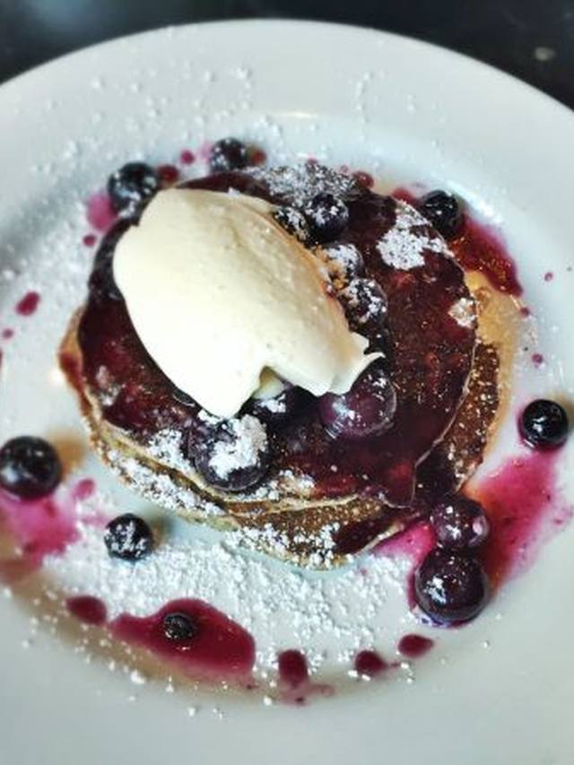 Stack of blueberry ricotta pancakes with fresh berries on top