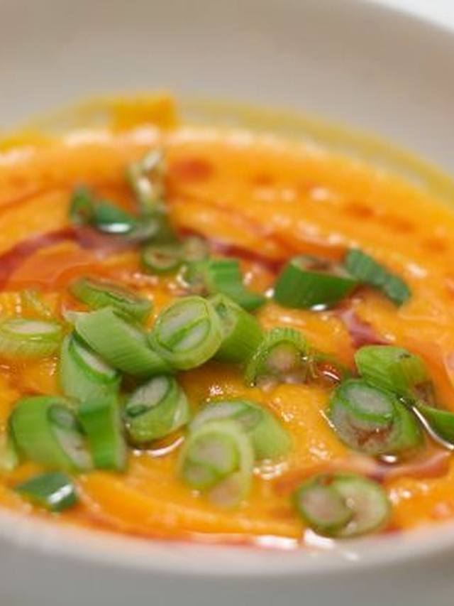 Smooth carrot ginger soup in a bowl with cracked pepper