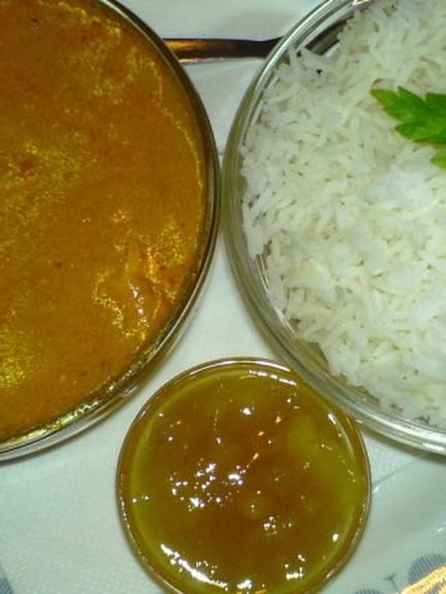 Chicken tikka masala in a bowl with rice and cilantro