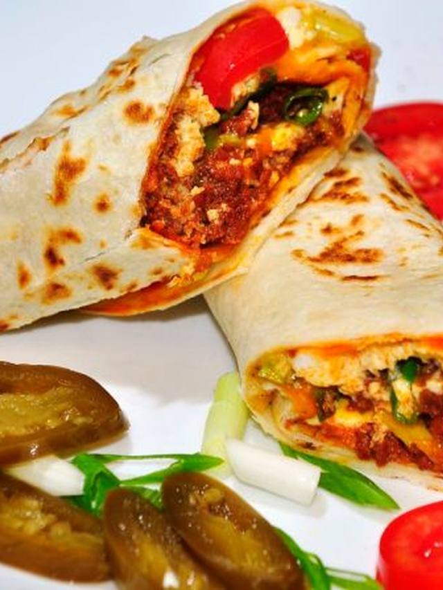 Three chorizo breakfast tacos with eggs and cilantro on a plate