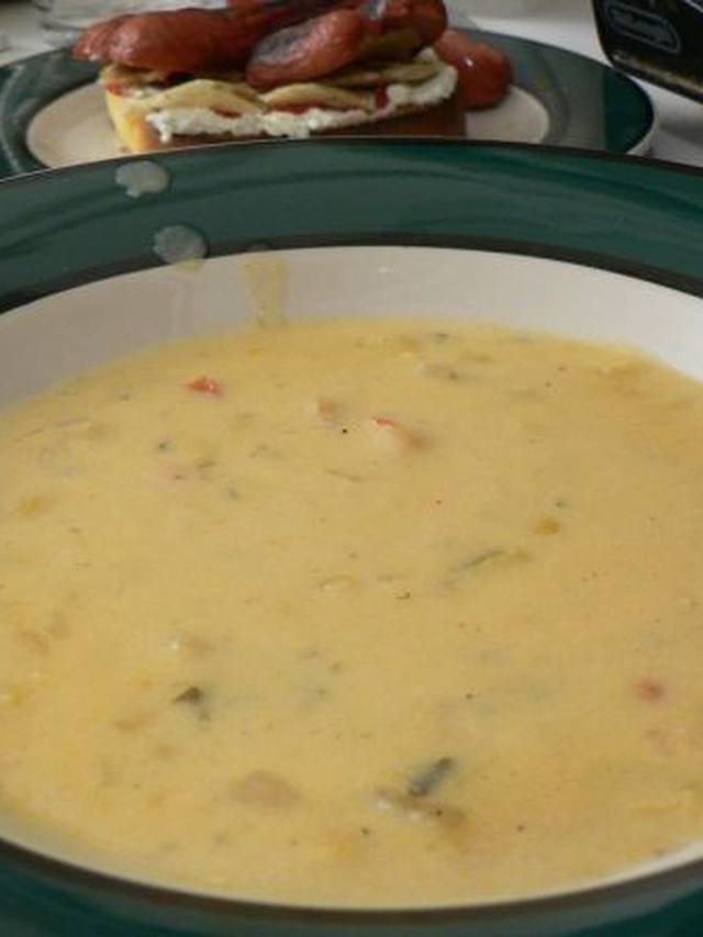 Pink shrimp and yellow corn kernels in a creamy sauce in a black skillet