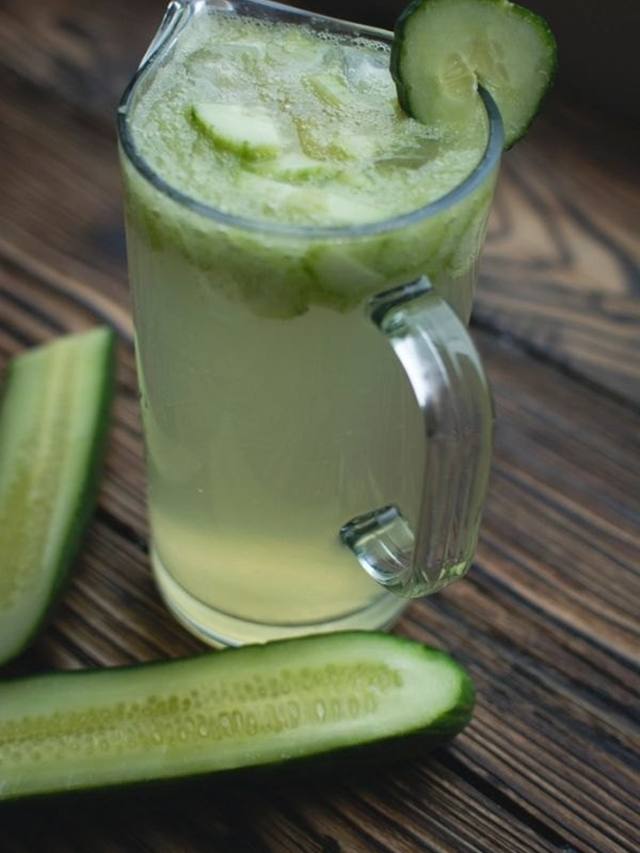 Pitcher and glass of pale green cucumber mint lemonade with ice