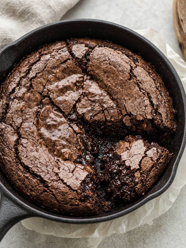 A skillet of fudgy brownies with a crinkled top.