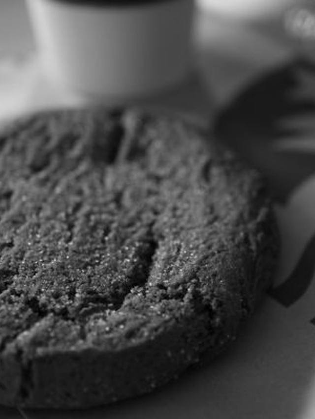 Stack of crackled ginger molasses cookies on a cooling rack