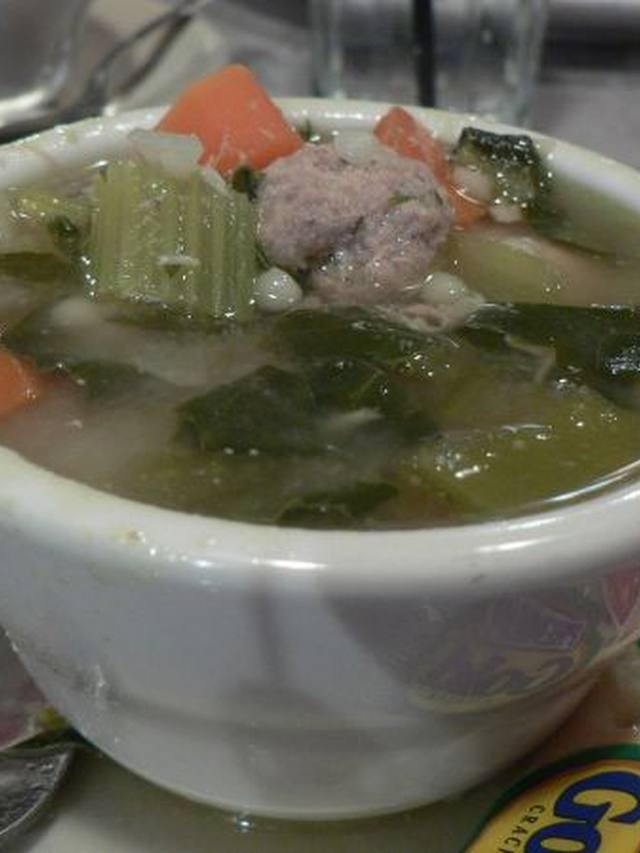 Clear broth soup with mini meatballs, spinach, and small pasta