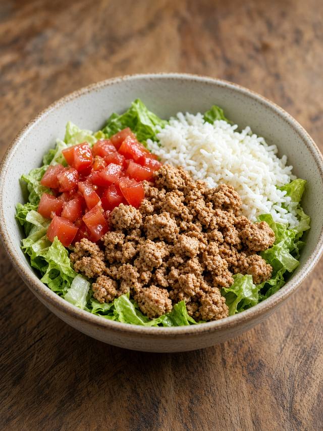 Turkey taco bowl with rice, beans, lettuce, and yogurt