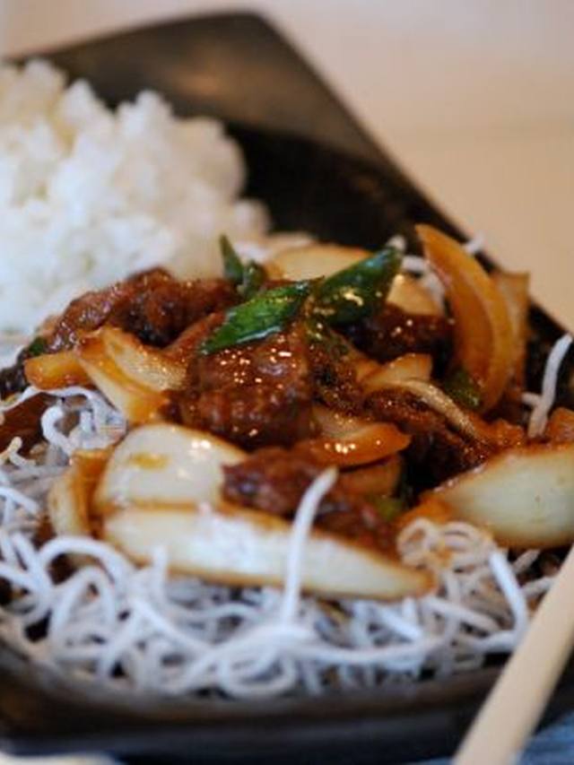 Glazed Mongolian beef strips with scallions in a skillet