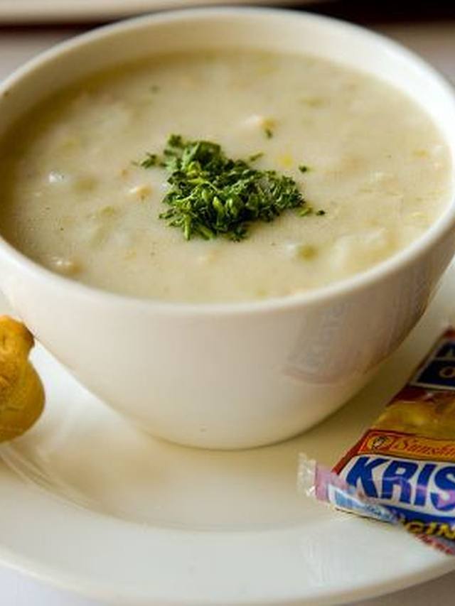Creamy white clam chowder in a bowl with diced potatoes and parsley