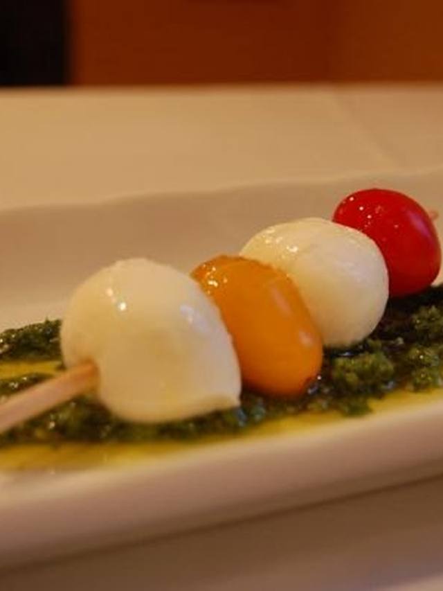 Roasted cherry tomatoes and melted mozzarella bites on a tray
