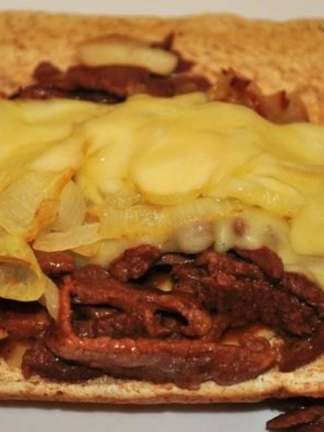 Skillet of shaved beef with peppers onions and melted provolone