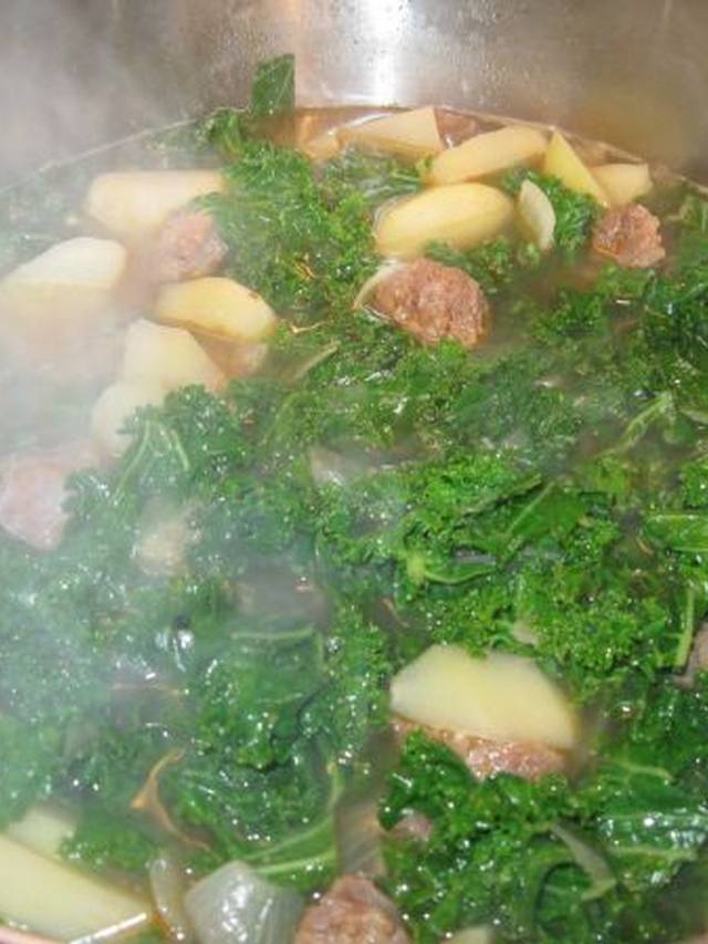 Bowl of sausage kale potato soup with visible sausage pieces and greens