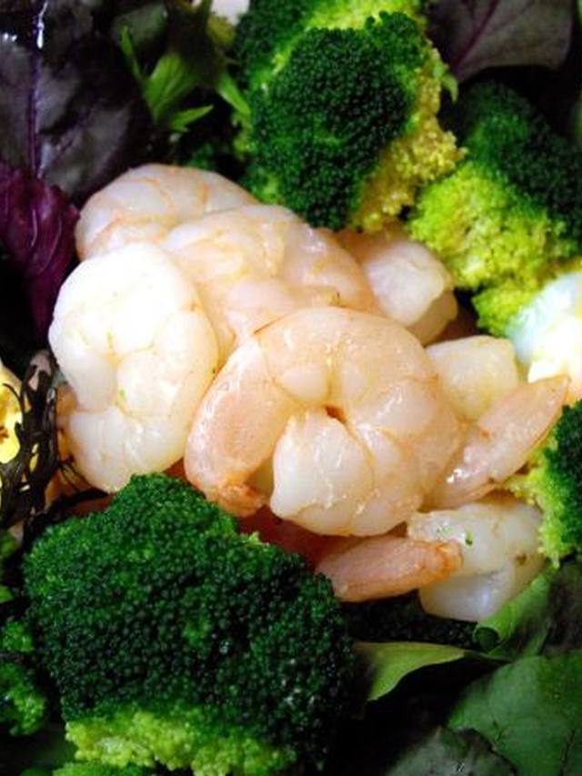 Roasted shrimp and broccoli florets on a sheet pan with paprika seasoning