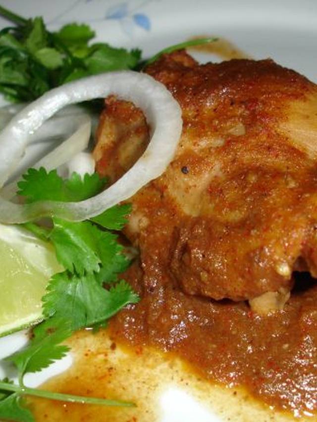 Slow cooker chicken curry in a bowl over rice with cilantro