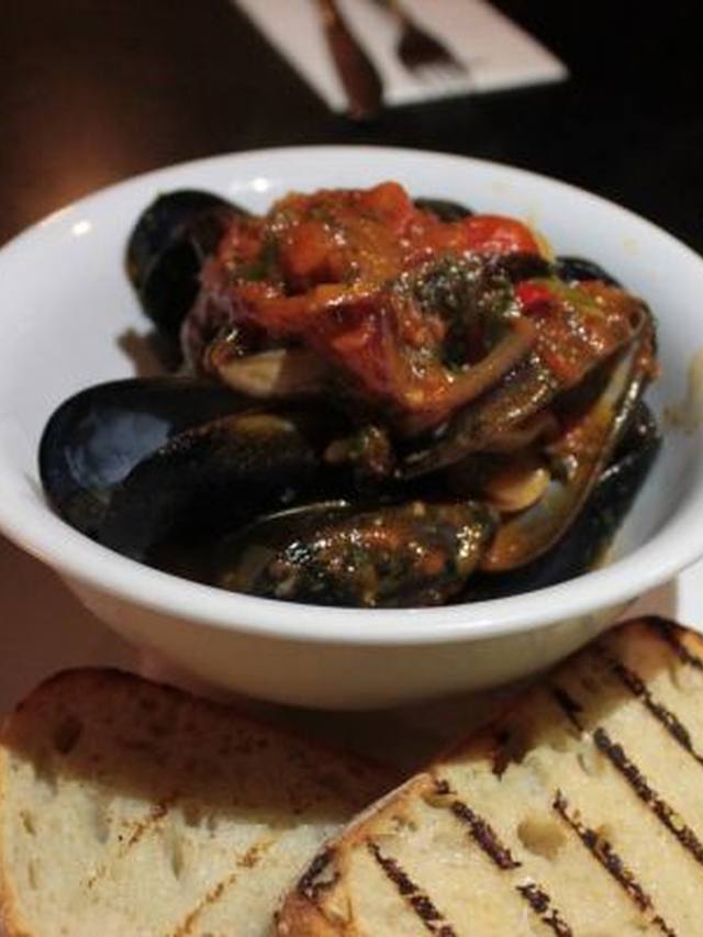 Steamed mussels in a white wine broth in a deep pot