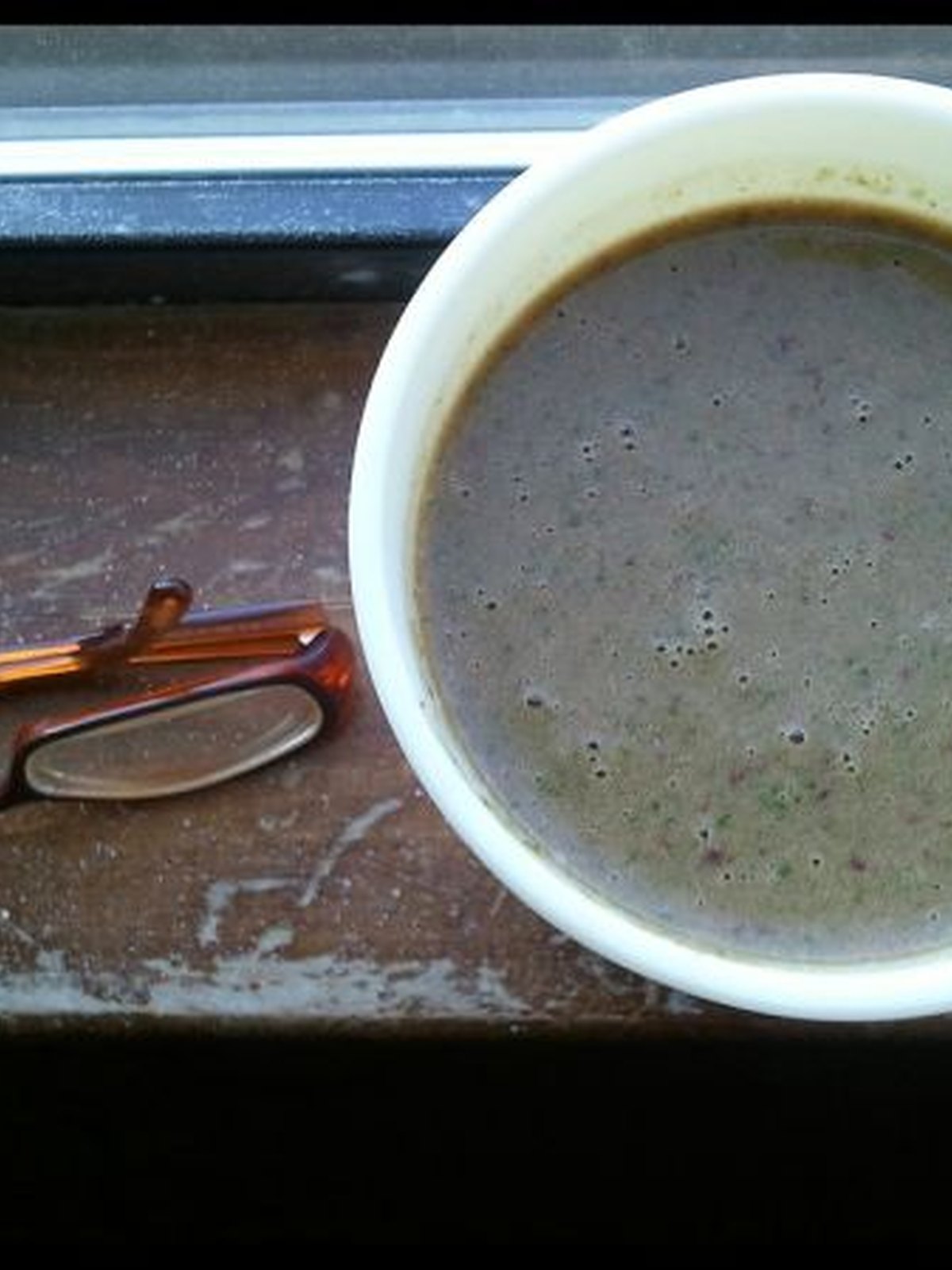 Brown chocolate peanut butter smoothie in a tall glass