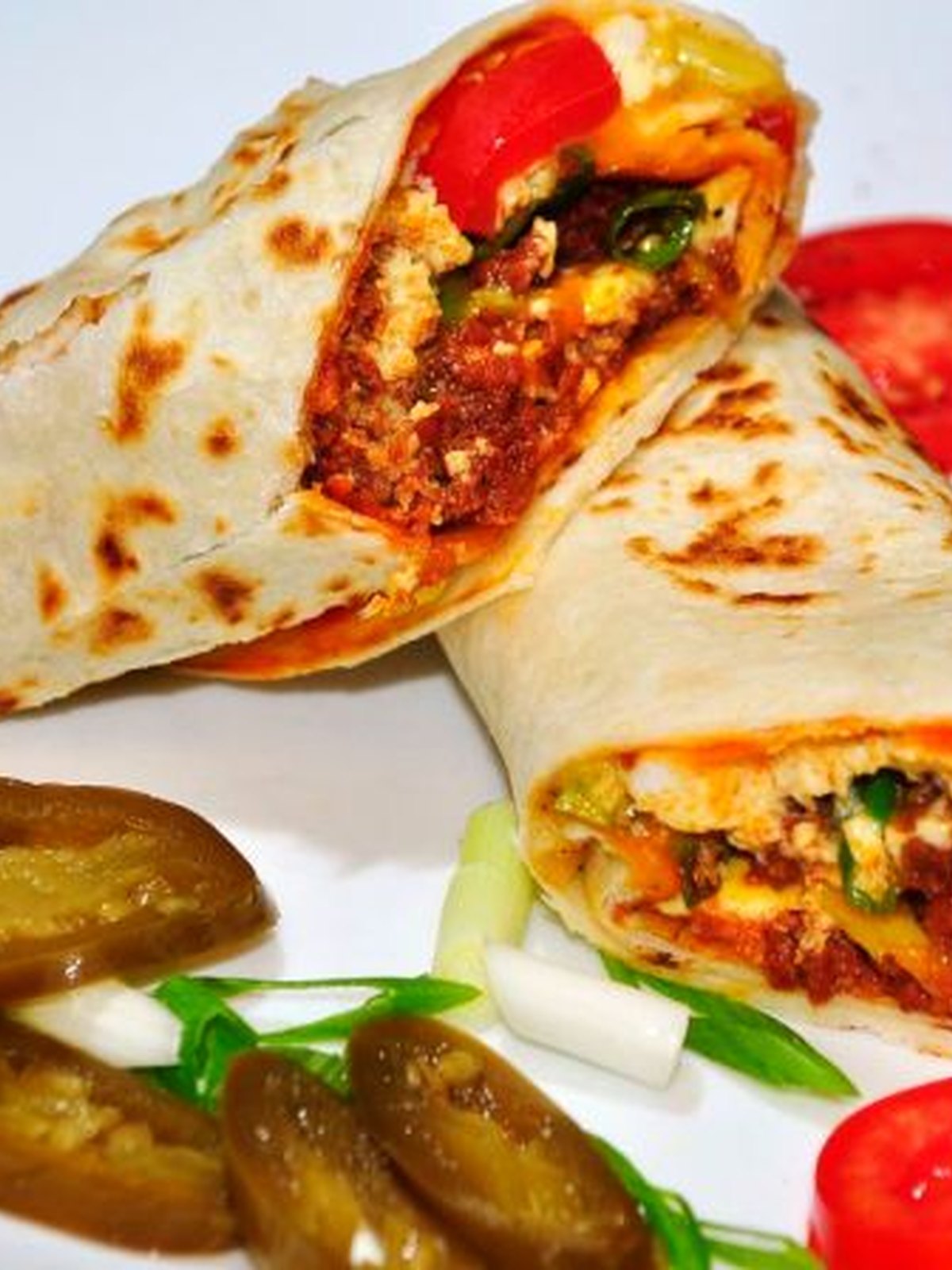 Three chorizo breakfast tacos with eggs and cilantro on a plate