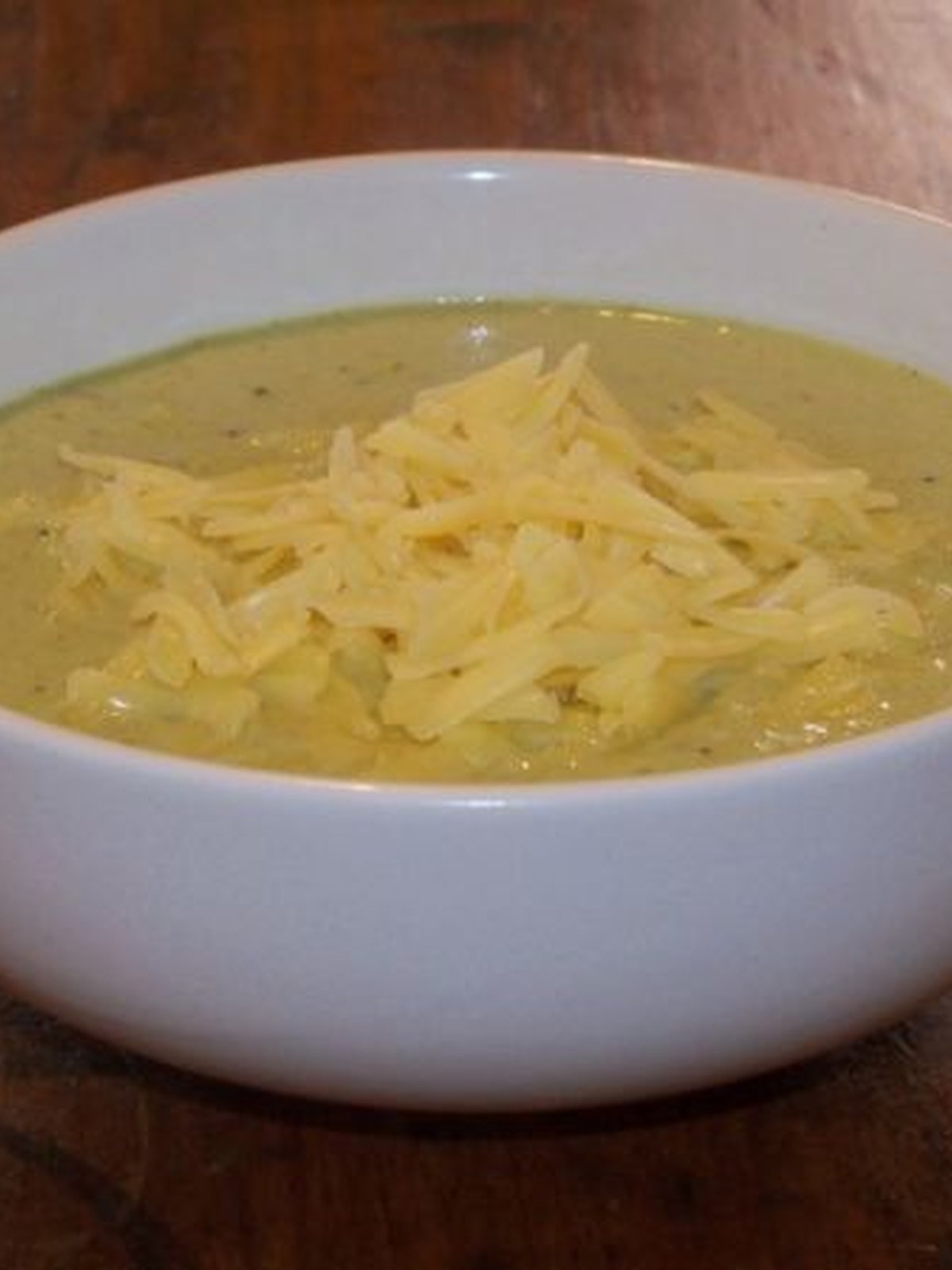 Thick broccoli cheddar soup in a bowl with visible broccoli pieces