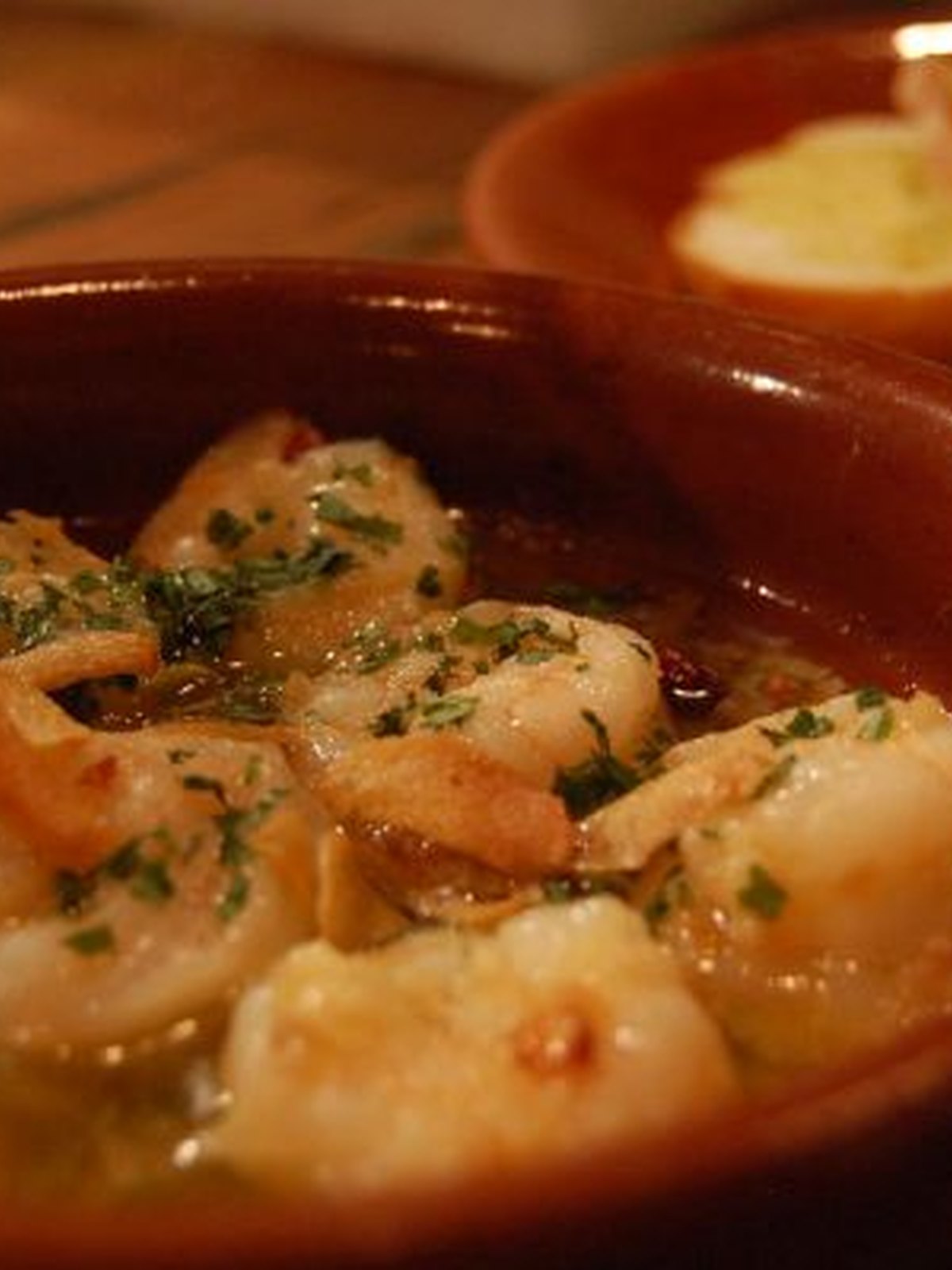 Shrimp in garlic and chili oil in a skillet with parsley