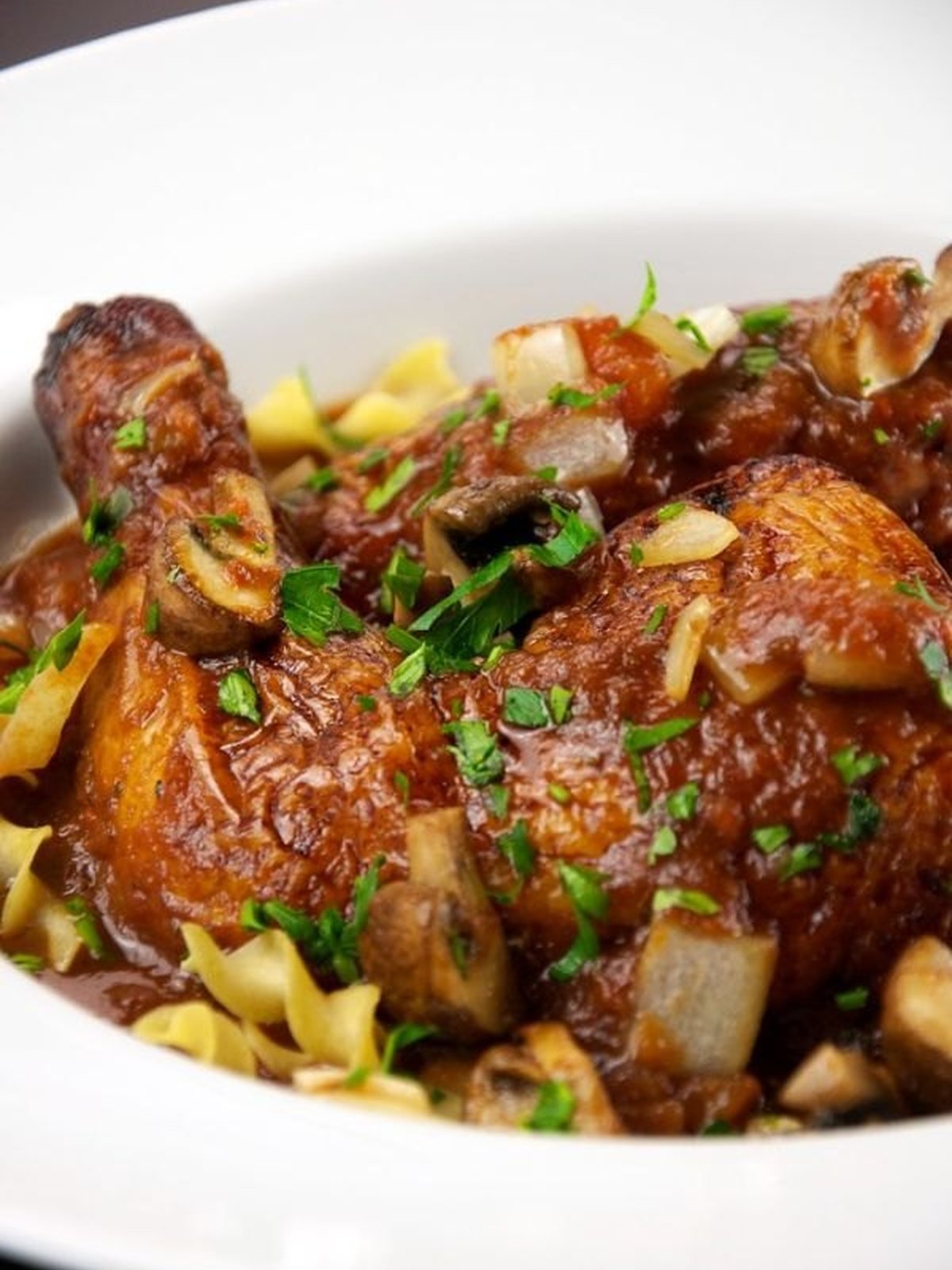 Bowl of chicken cacciatore with peppers and tomato sauce